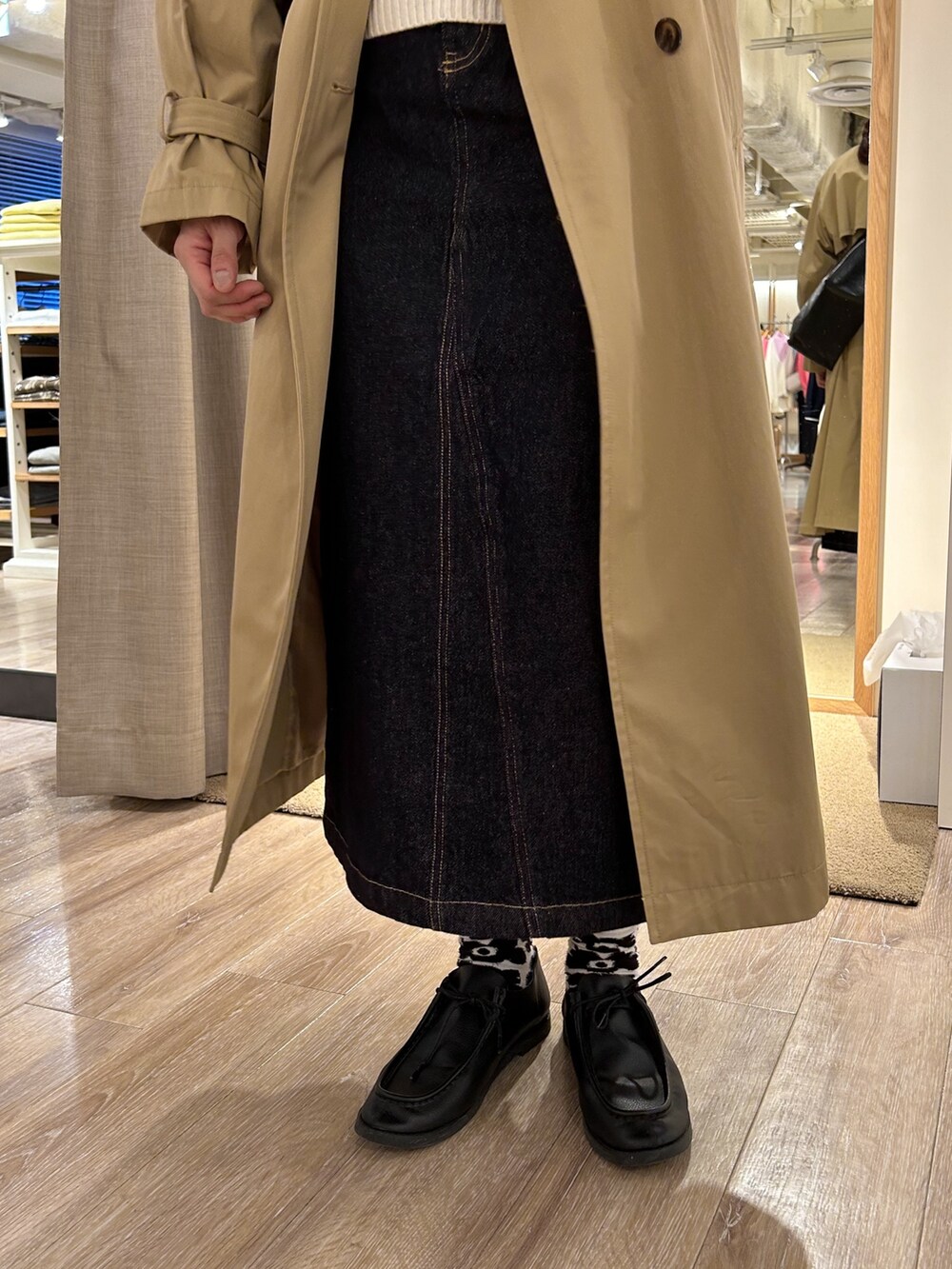 ホワイト系のベスト、ブルー系のデニムスカート、ブラック系のショルダーバッグを着用したレディースの冬コーディネートの4枚目の写真