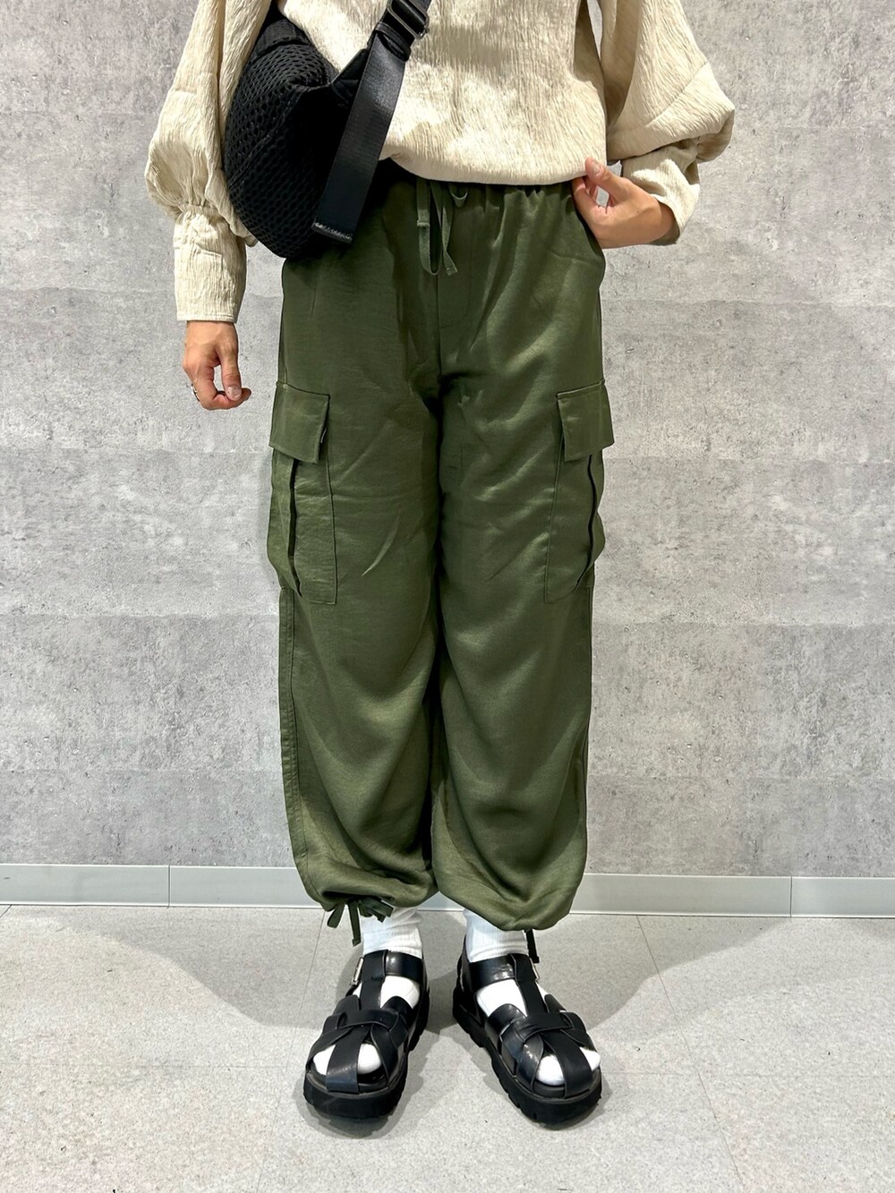 ベージュ系のシャツ/ブラウス、グリーン系のカーゴパンツ、ブラック系のショルダーバッグを着用したレディースの夏コーディネートの3枚目の写真