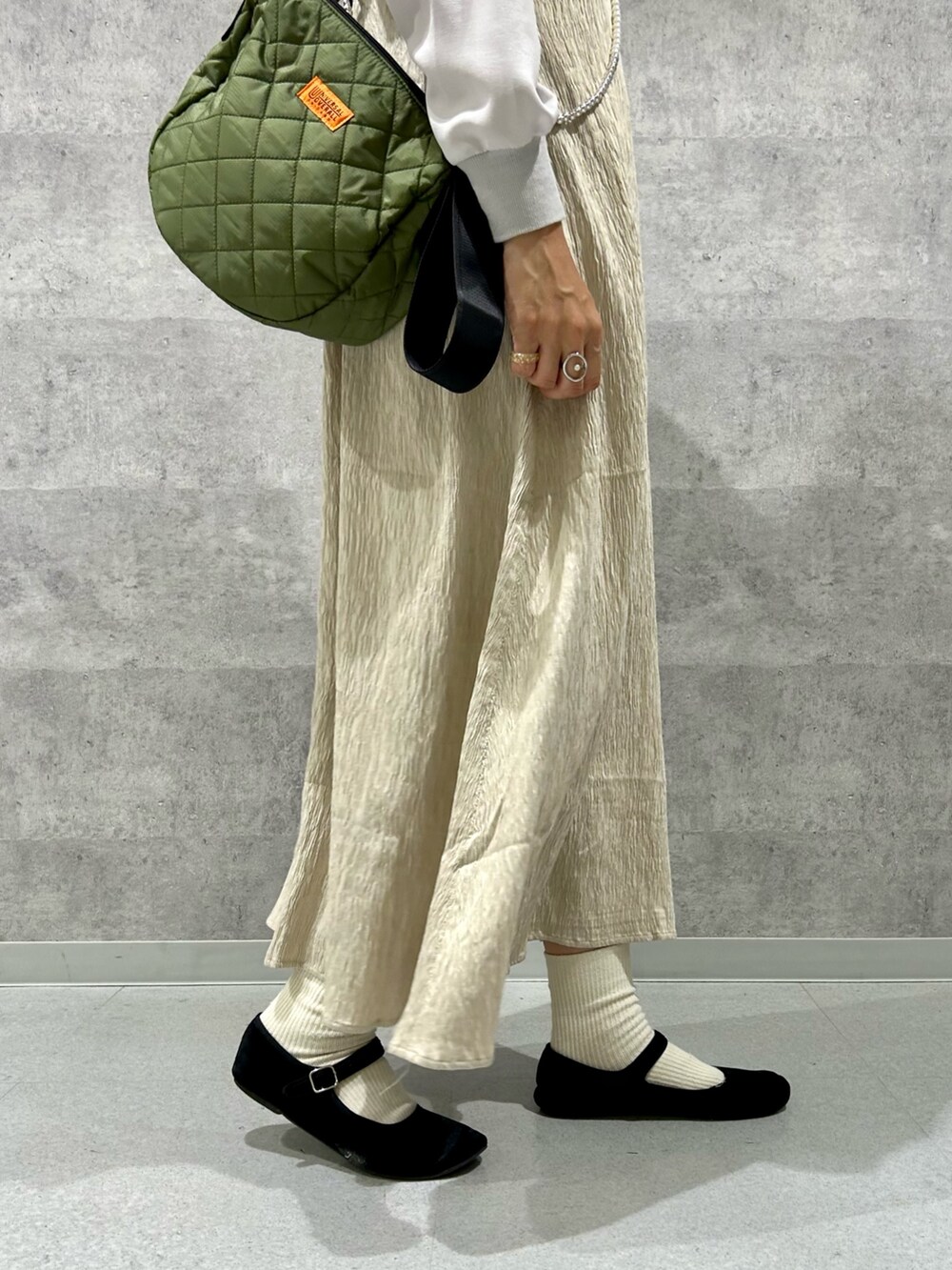 グレー系のシャツ/ブラウス、ベージュ系のワンピース、グリーン系のショルダーバッグを着用したレディースの秋コーディネートの3枚目の写真