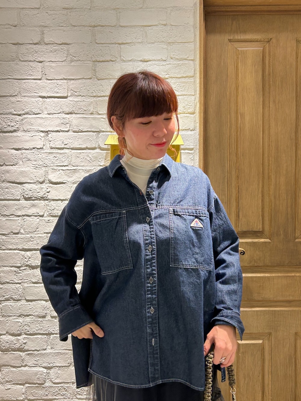 ブルー系のシャツ/ブラウス、ホワイト系のTシャツ/カットソー、グレー系のスカートを着用したレディースの冬コーディネートの2枚目の写真