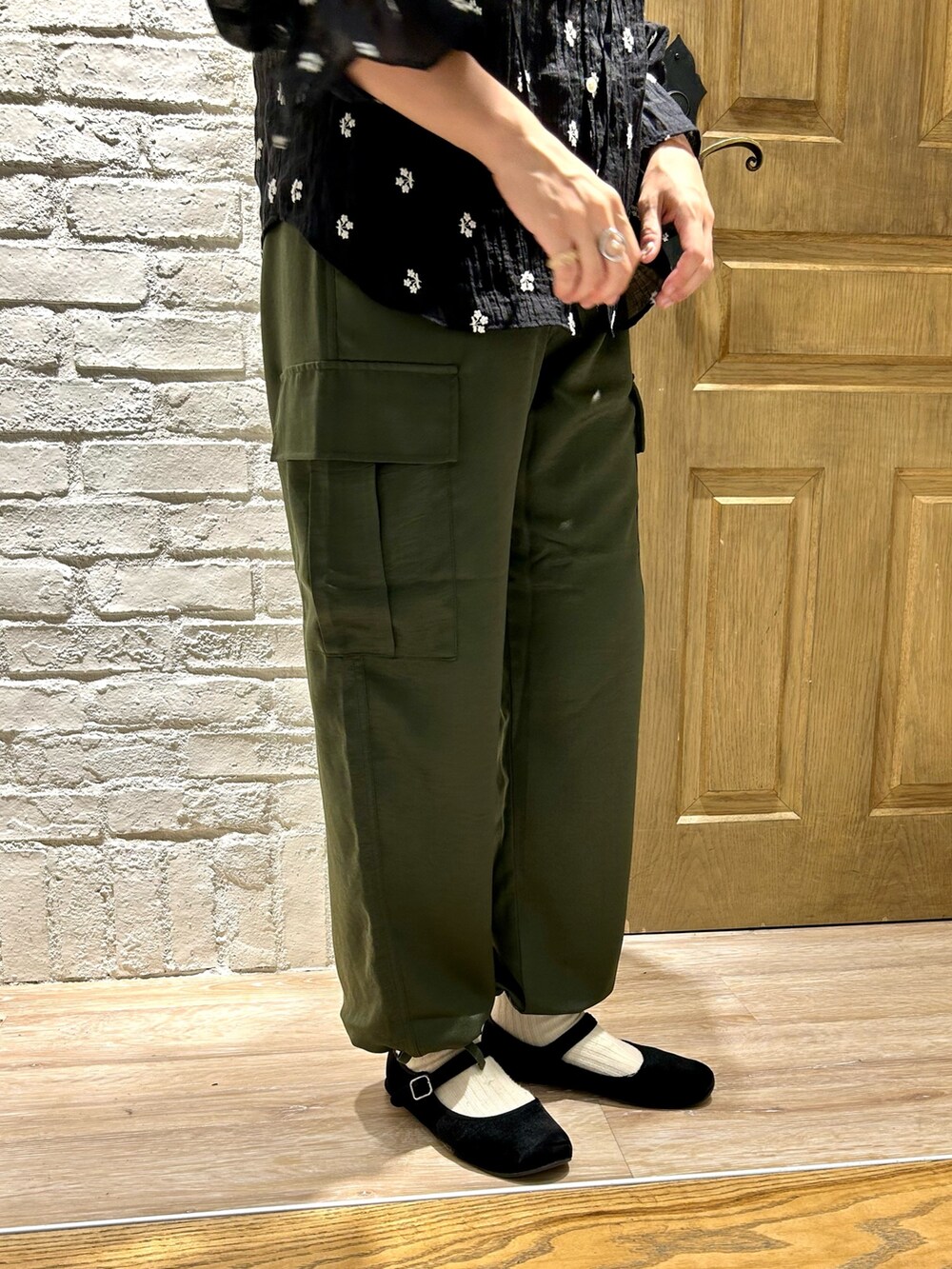 ホワイト系のTシャツ/カットソー、ブラック系のシャツ/ブラウス、グリーン系のカーゴパンツを着用したレディースの秋コーディネートの4枚目の写真