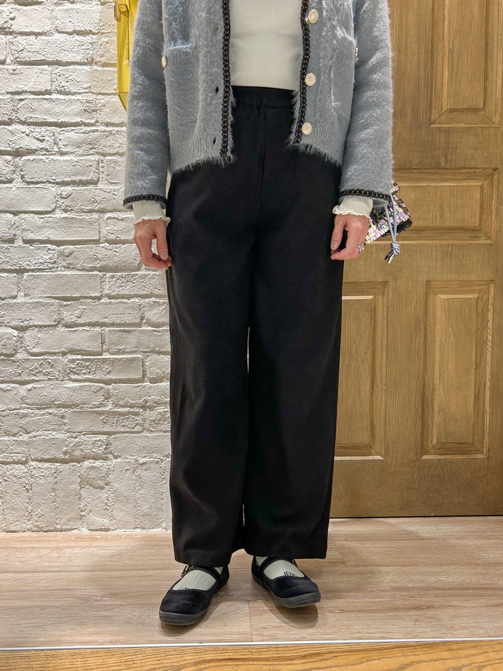 グレー系のカーディガン/ボレロ、ホワイト系のTシャツ/カットソー、シルバー系のショルダーバッグを着用したレディースの冬コーディネートの3枚目の写真