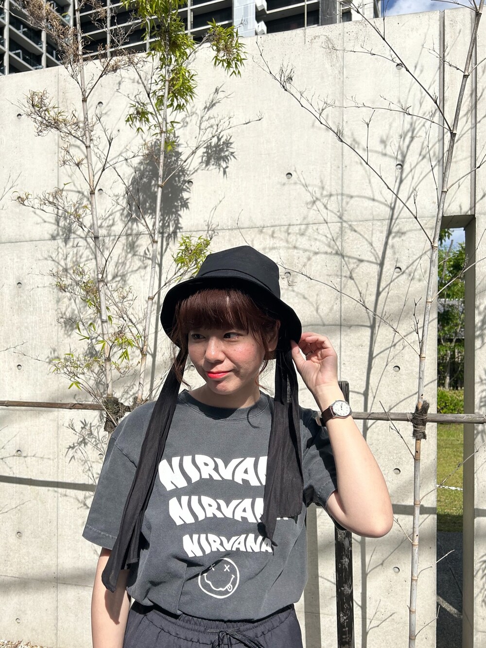グレー系のTシャツ/カットソー、ブラック系のスラックス、ベージュ系のトートバッグを着用したレディースの春コーディネートの2枚目の写真