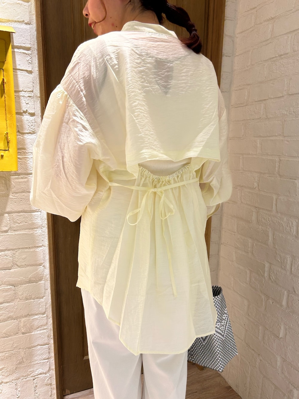 ホワイト系のシャツ/ブラウス、ホワイト系のタンクトップ、シルバー系のトートバッグを着用したレディースの春コーディネートの2枚目の写真