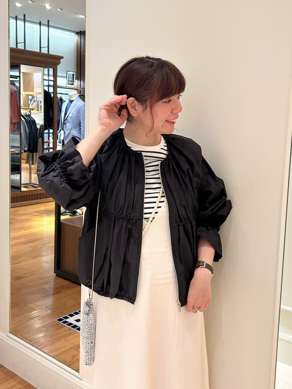 ブラック系のブルゾン、ブラック系のTシャツ/カットソー、ホワイト系のワンピースを着用したレディースの春コーディネートの2枚目の写真