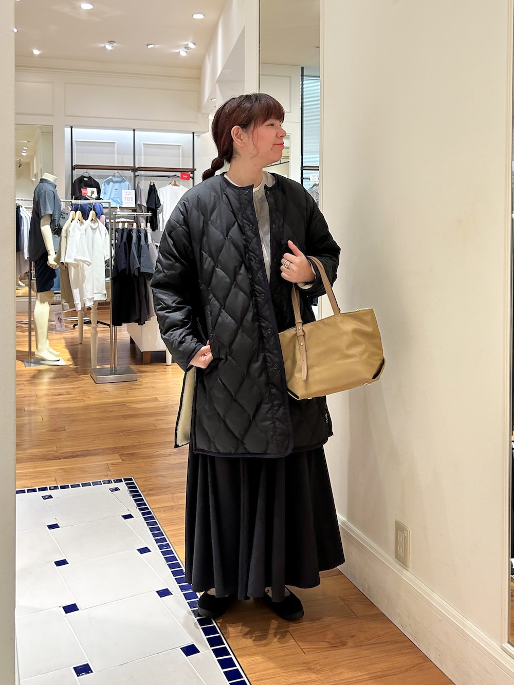 グレー系のブルゾン、ホワイト系のダウンジャケット/コート、ブラウン系のショルダーバッグを着用したレディースの秋コーディネートの3枚目の写真