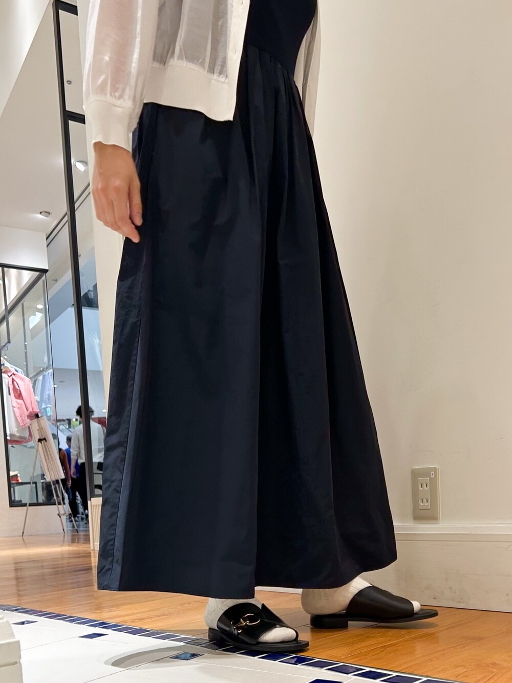 ブルー系のワンピース、ホワイト系のカーディガン/ボレロ、ブラウン系のサングラスを着用したレディースの春コーディネートの3枚目の写真