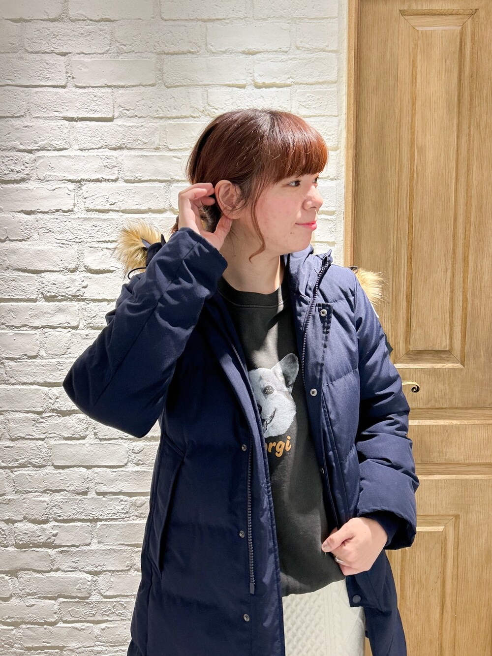 ベージュ系のショルダーバッグ、ホワイト系のスカート、ブルー系のダウンジャケット/コートを着用したレディースの冬コーディネートの2枚目の写真
