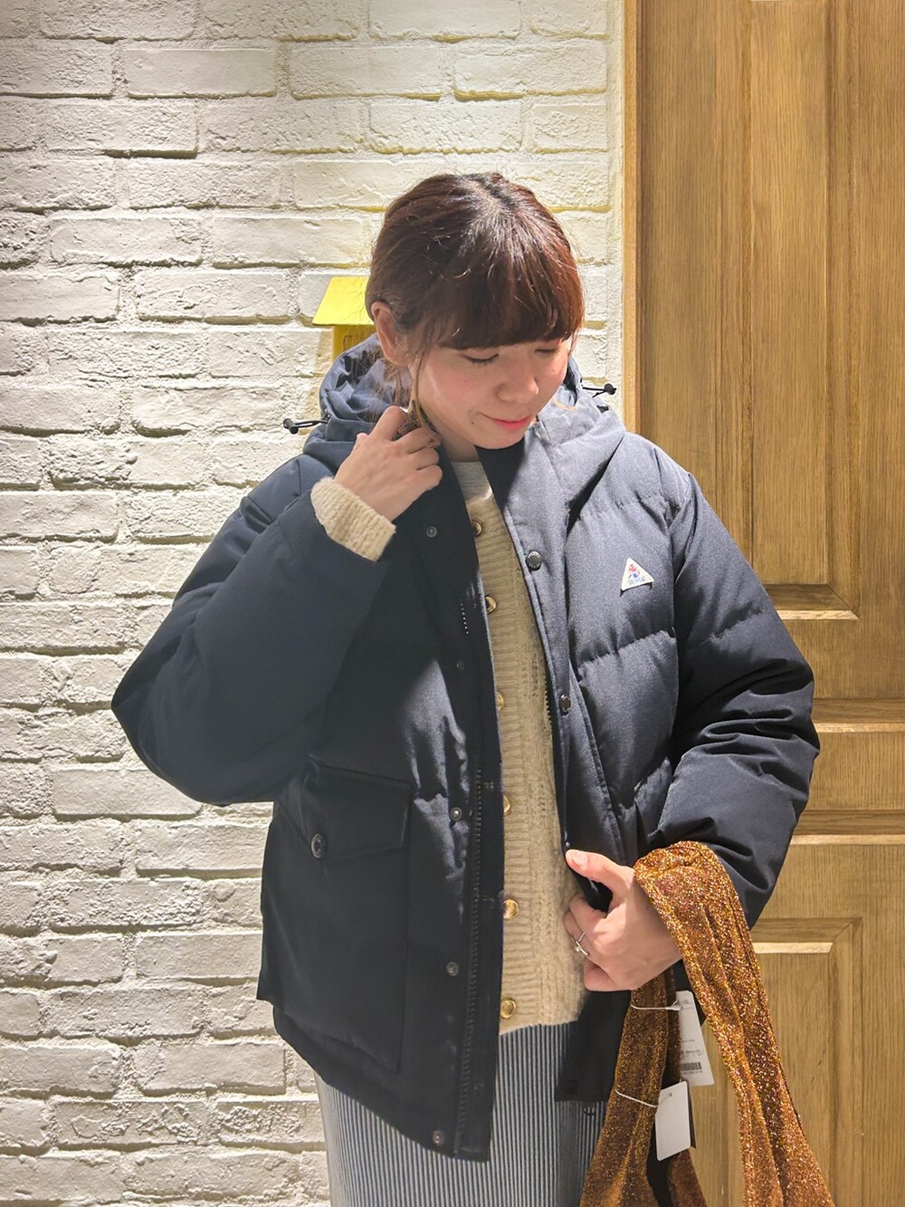 ブルー系のダウンジャケット/コート、ブルー系のスカート、ホワイト系のカーディガン/ボレロを着用したレディースの冬コーディネートの2枚目の写真