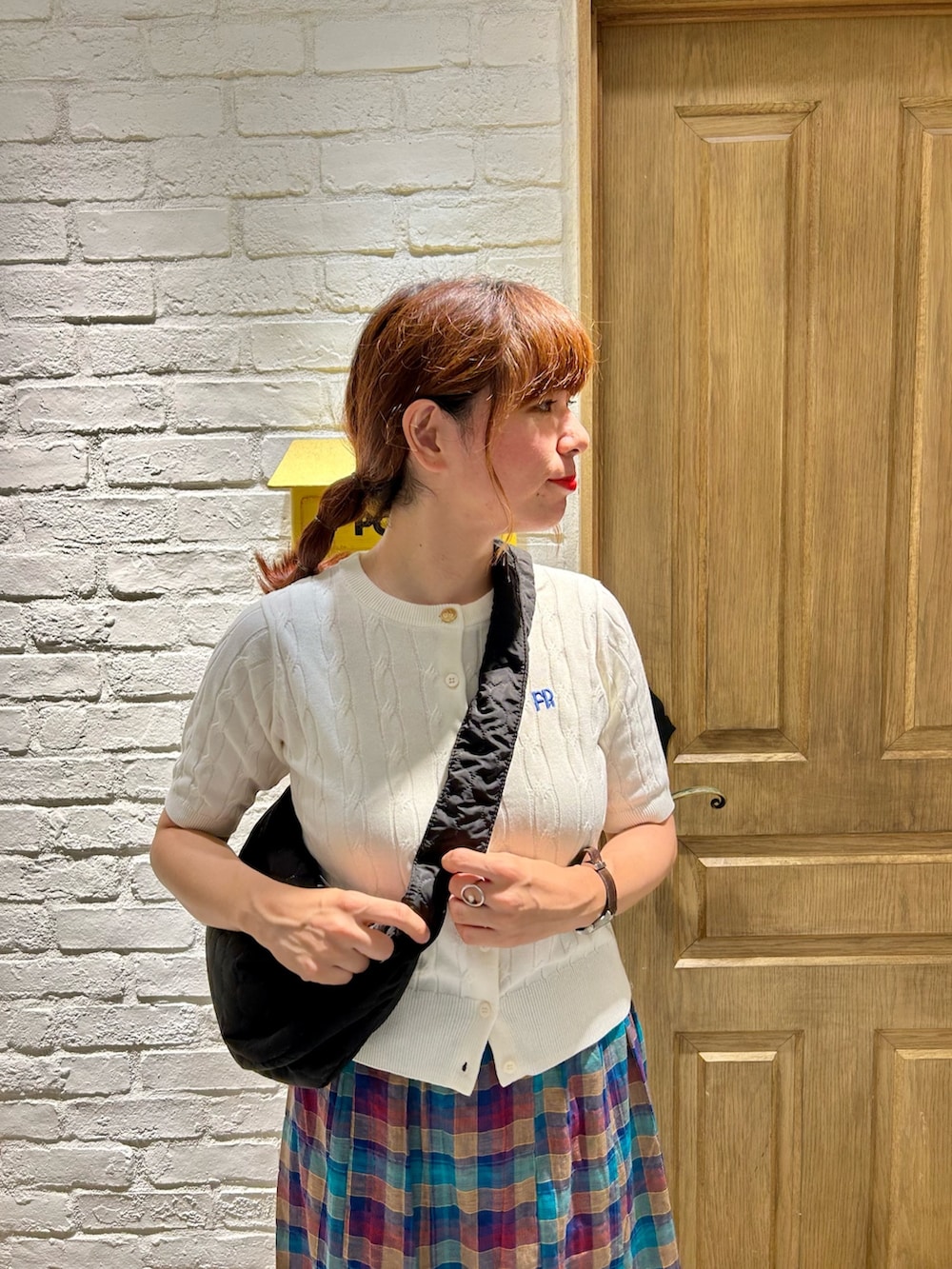 ホワイト系のカーディガン/ボレロ、ブルー系のスカート、ブラック系のショルダーバッグを着用したレディースの夏コーディネートの2枚目の写真