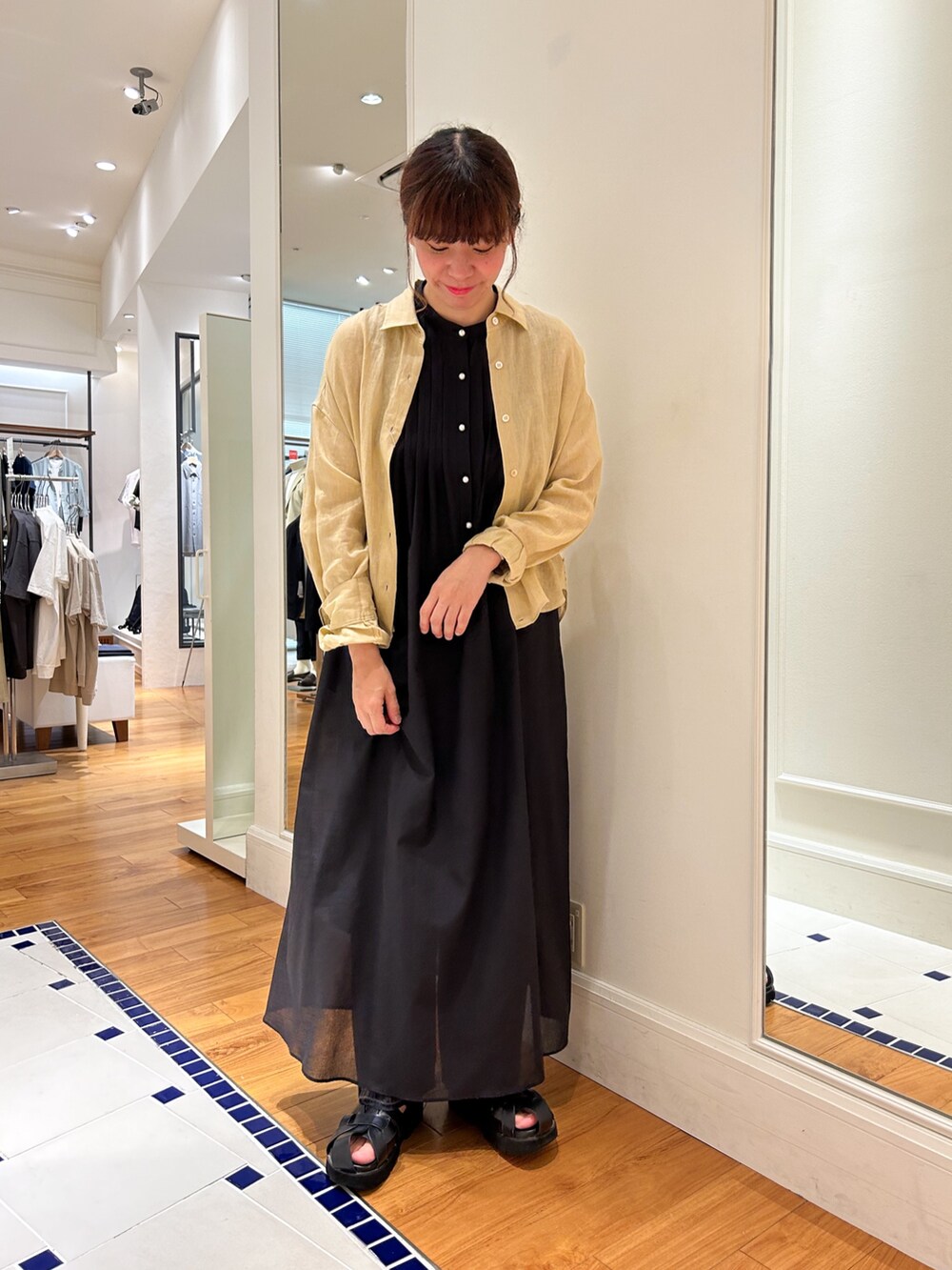 グレー系のデニムパンツ、ベージュ系のシャツ/ブラウス、ブラック系のシャツワンピースを着用したレディースの夏コーディネートの2枚目の写真