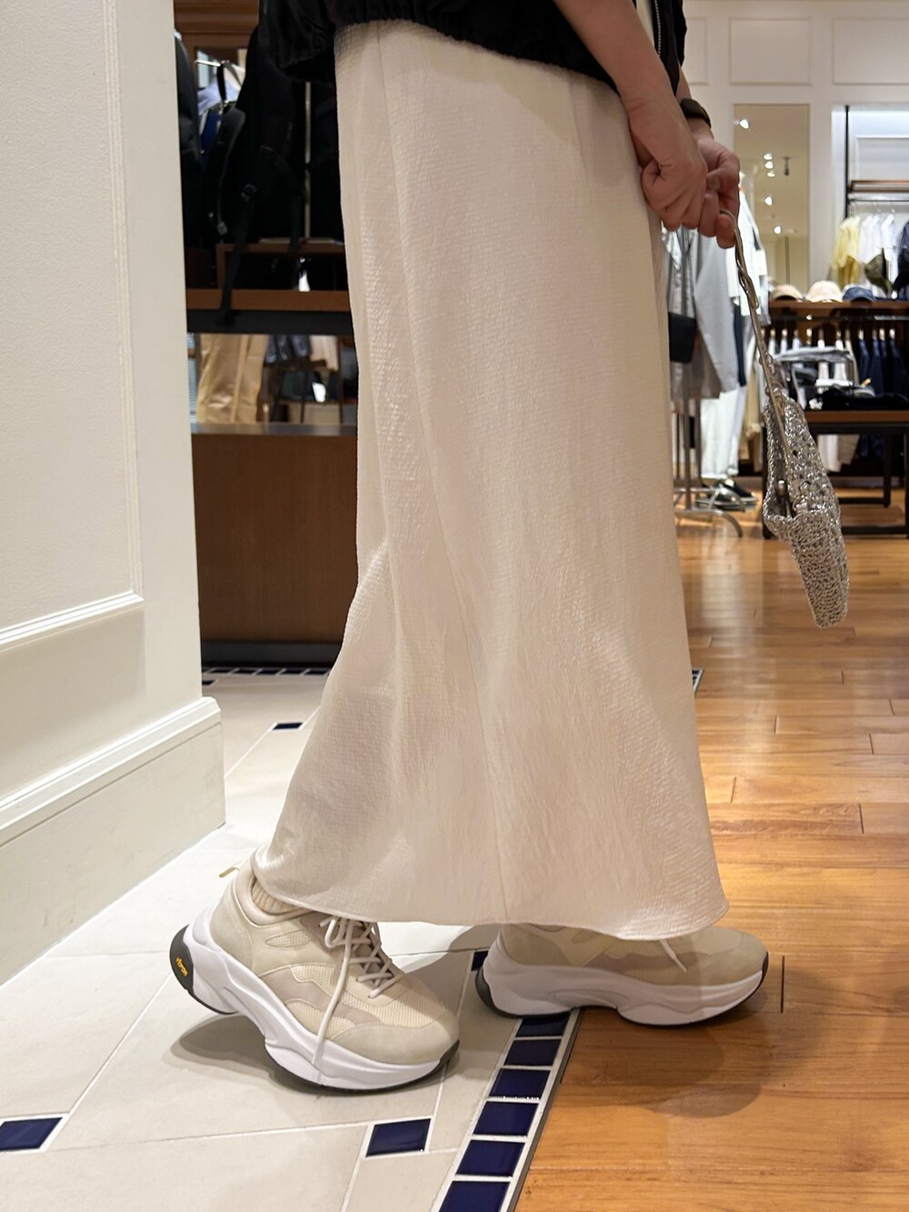 ホワイト系のワンピース、シルバー系のショルダーバッグ、ブラック系のTシャツ/カットソーを着用したレディースの春コーディネートの3枚目の写真