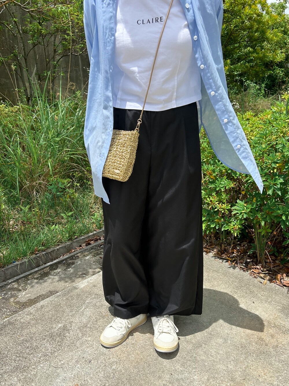 ブルー系のシャツ/ブラウス、ブラック系のその他パンツ、ゴールド系のショルダーバッグを着用したレディースの夏コーディネートの3枚目の写真