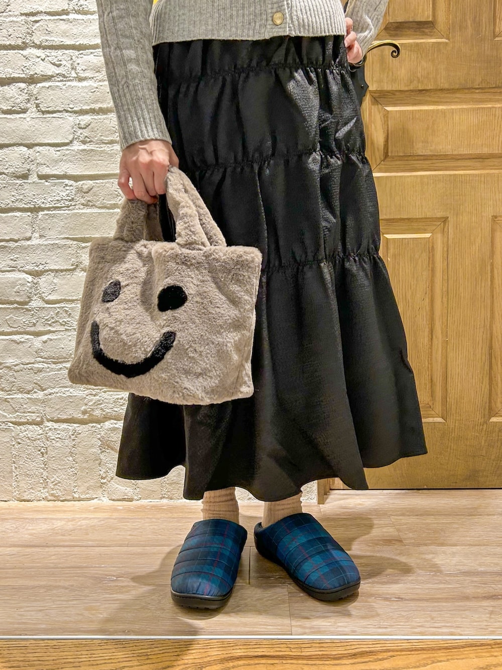 グレー系のカーディガン/ボレロ、ブラック系のスカート、グレー系のトートバッグを着用したレディースの秋コーディネートの3枚目の写真