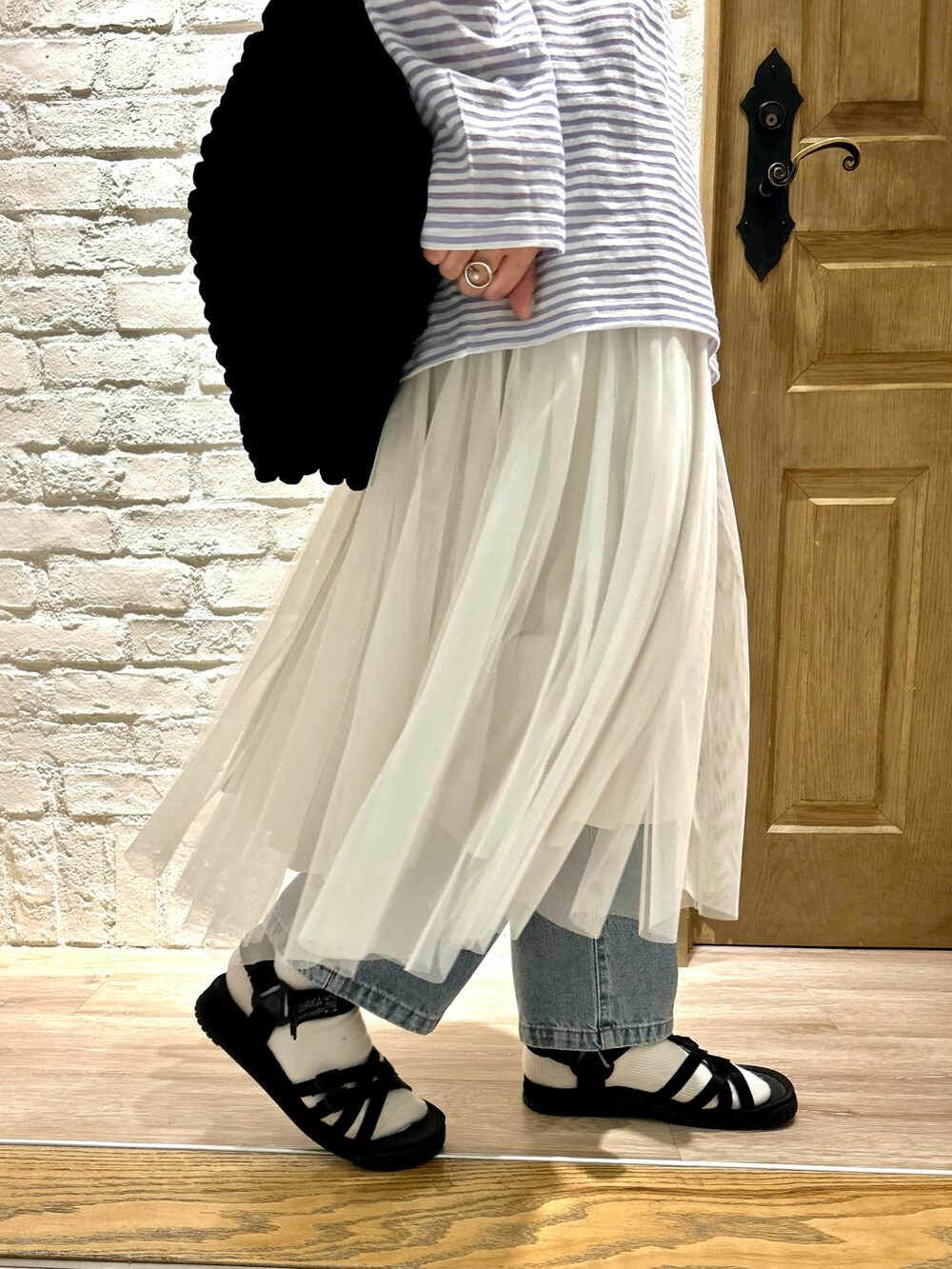 ブルー系のデニムパンツ、ブラック系のサンダル、ブルー系のTシャツ/カットソーを着用したレディースの夏コーディネートの3枚目の写真