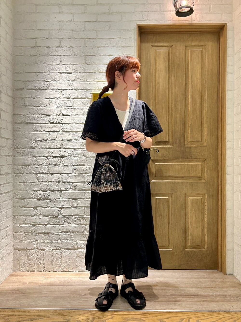 ブラック系のショルダーバッグ、ホワイト系のTシャツ/カットソー、ブルー系のデニムジャケットを着用したレディースの夏コーディネートの3枚目の写真
