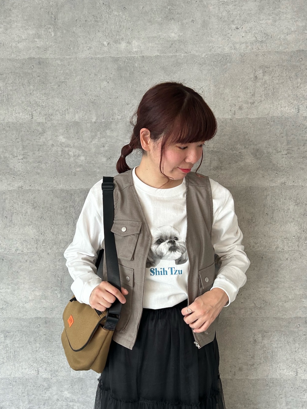 ベージュ系のベスト、ホワイト系のTシャツ/カットソー、ブラック系のスカートを着用したレディースの春コーディネートの2枚目の写真