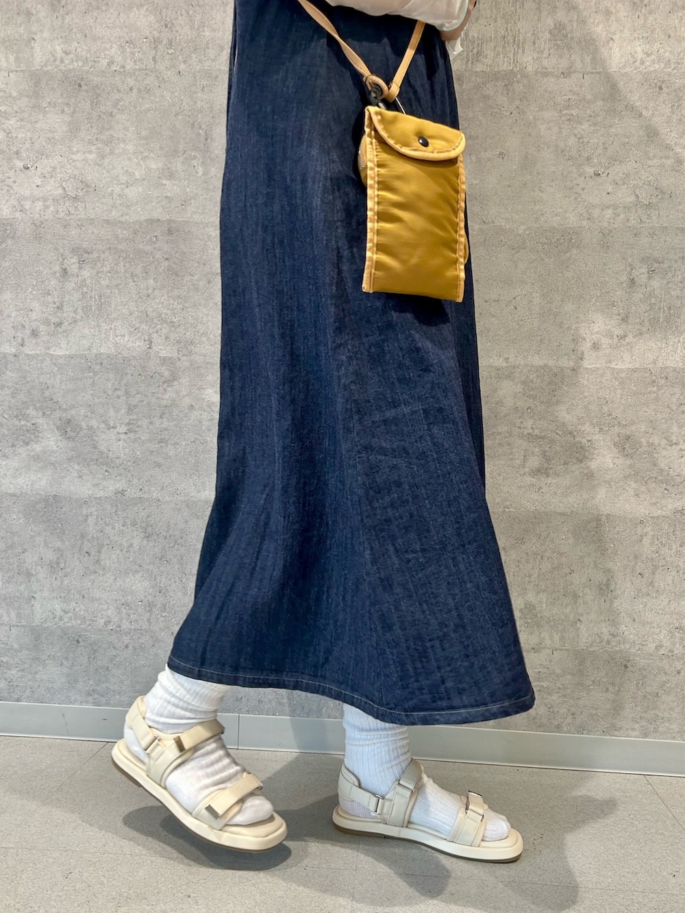 ホワイト系のサンダル、ベージュ系のショルダーバッグ、ブルー系のワンピースを着用したレディースの春コーディネートの4枚目の写真