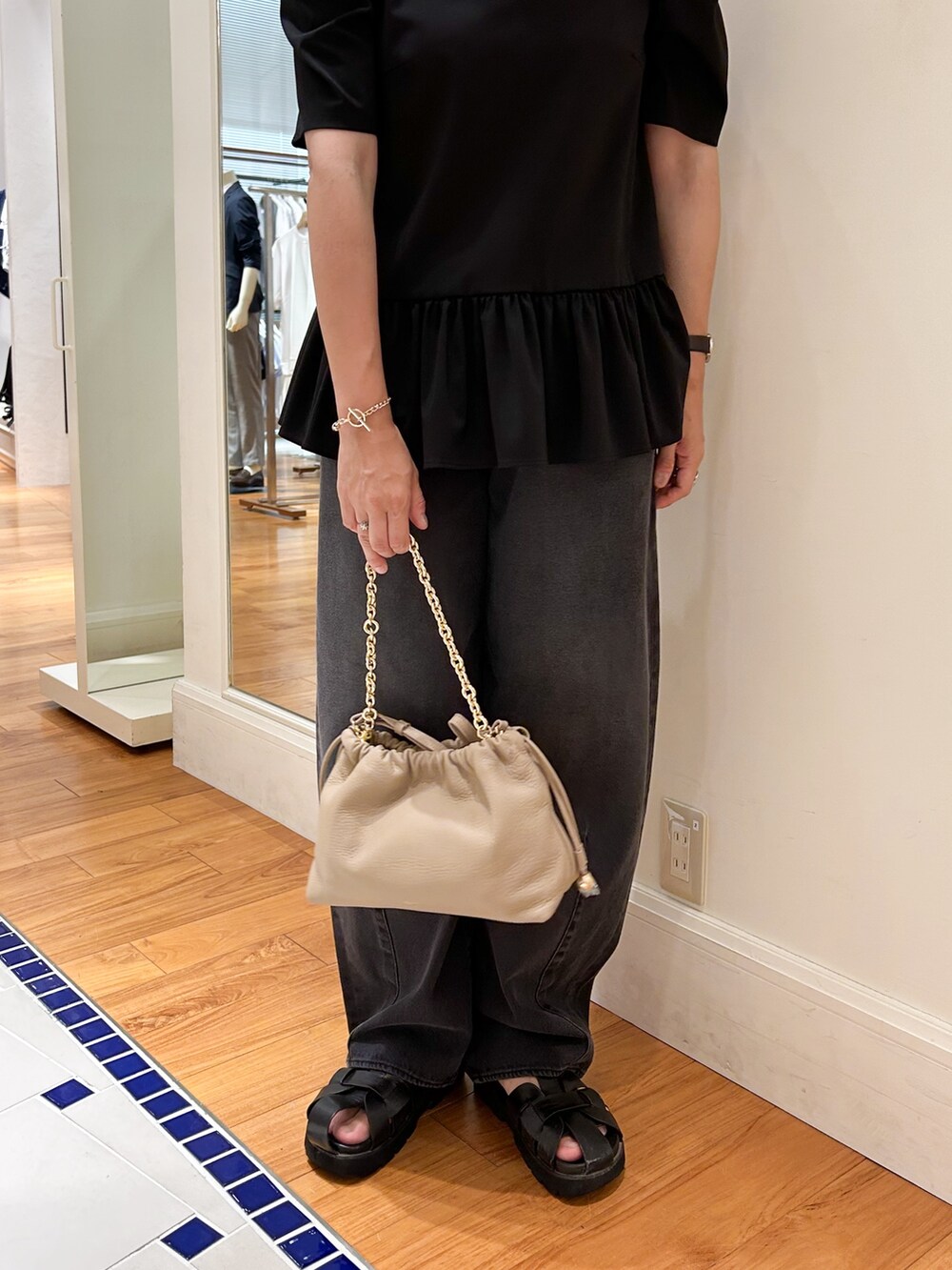 ベージュ系のショルダーバッグ、ブラック系のTシャツ/カットソー、グレー系のデニムパンツを着用したレディースの夏コーディネートの4枚目の写真