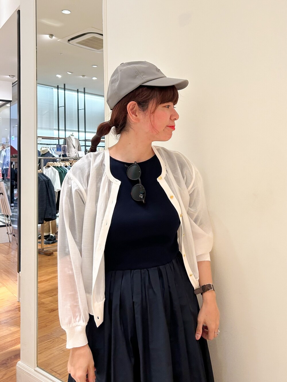 ブルー系のワンピース、ホワイト系のカーディガン/ボレロ、ブラウン系のサングラスを着用したレディースの春コーディネートの2枚目の写真