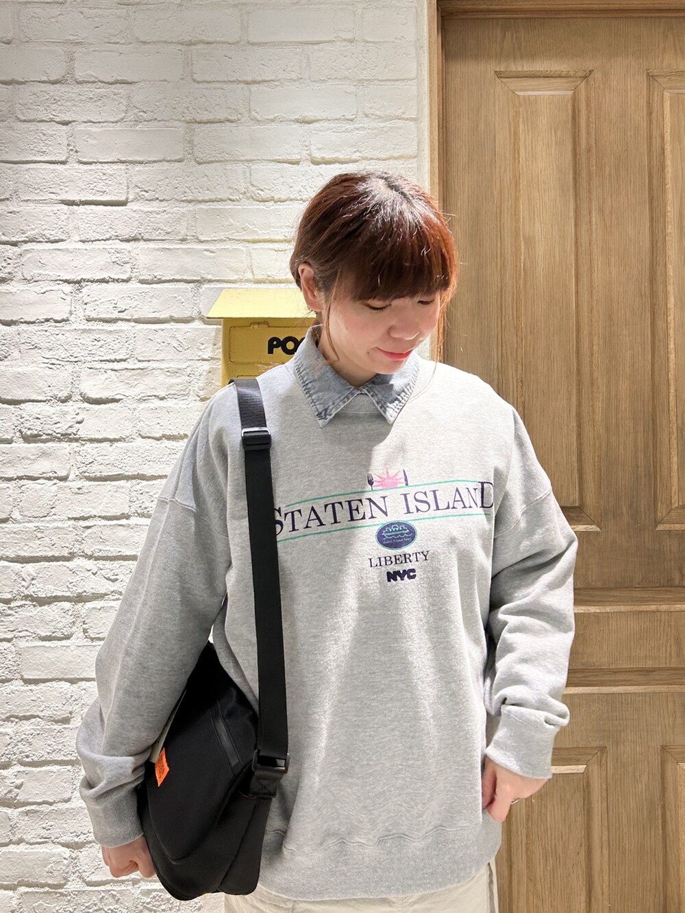 ベージュ系のスカート、グレー系のスウェット、ブルー系のシャツ/ブラウスを着用したレディースの春コーディネートの2枚目の写真