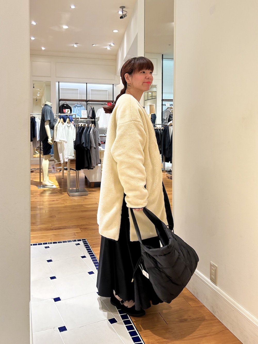 グレー系のブルゾン、ホワイト系のダウンジャケット/コート、ブラウン系のショルダーバッグを着用したレディースの秋コーディネートの2枚目の写真