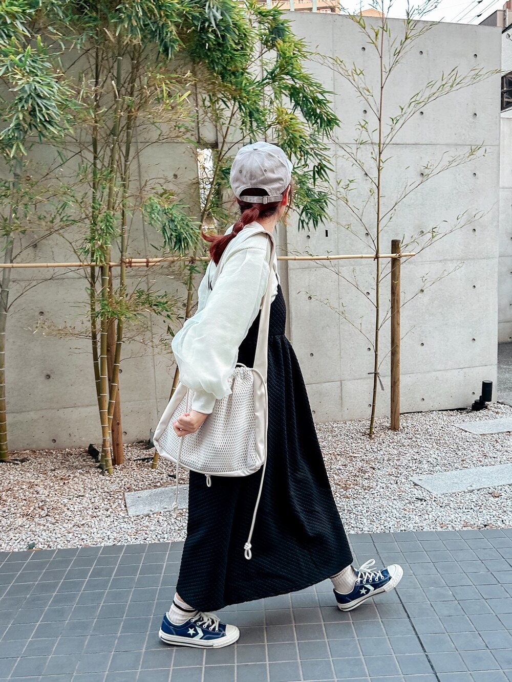 ホワイト系のショルダーバッグ、ブラック系のワンピース、ホワイト系のTシャツ/カットソーを着用したレディースの冬コーディネートの2枚目の写真