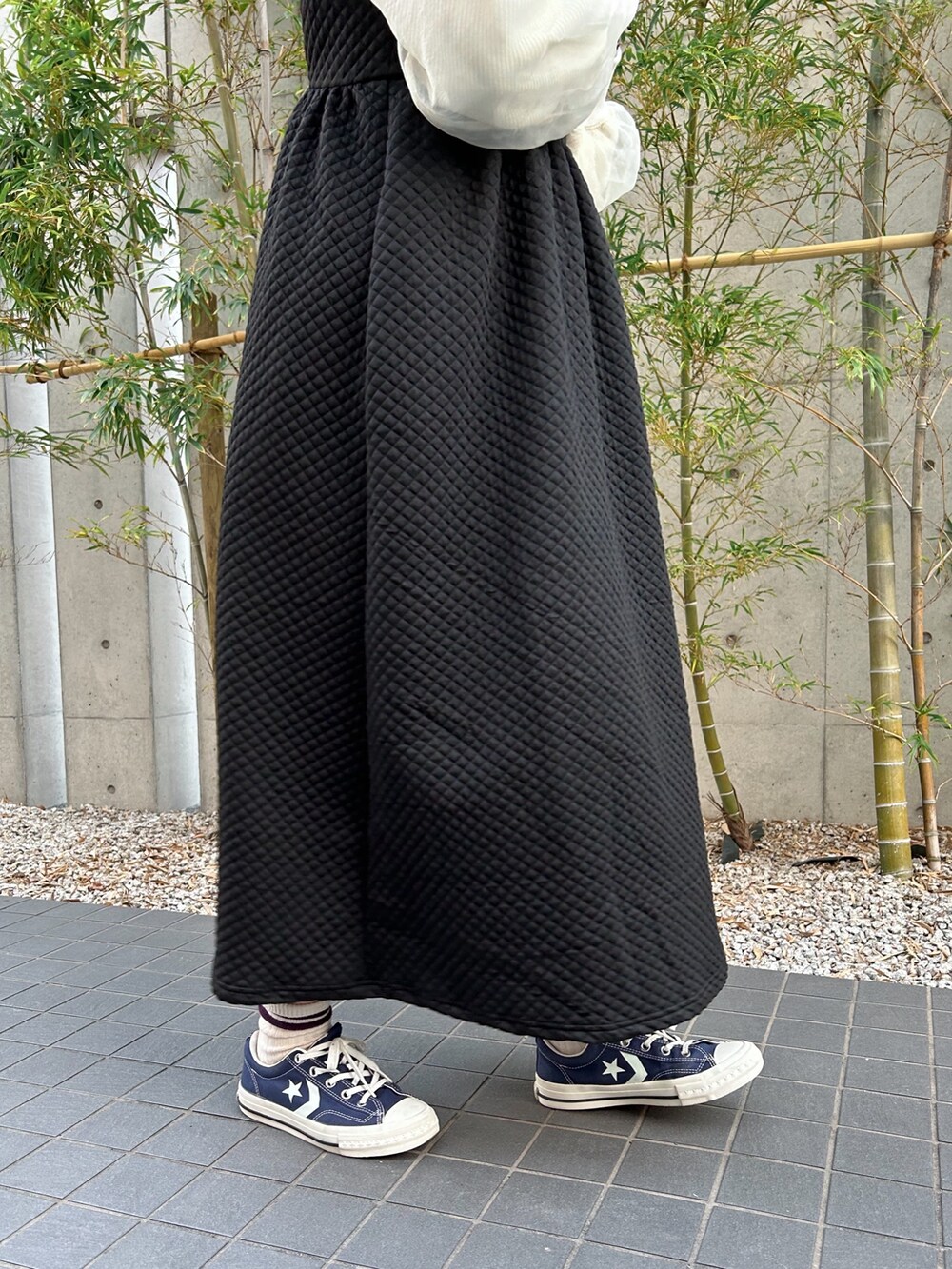 ホワイト系のショルダーバッグ、ブラック系のワンピース、ホワイト系のTシャツ/カットソーを着用したレディースの冬コーディネートの4枚目の写真