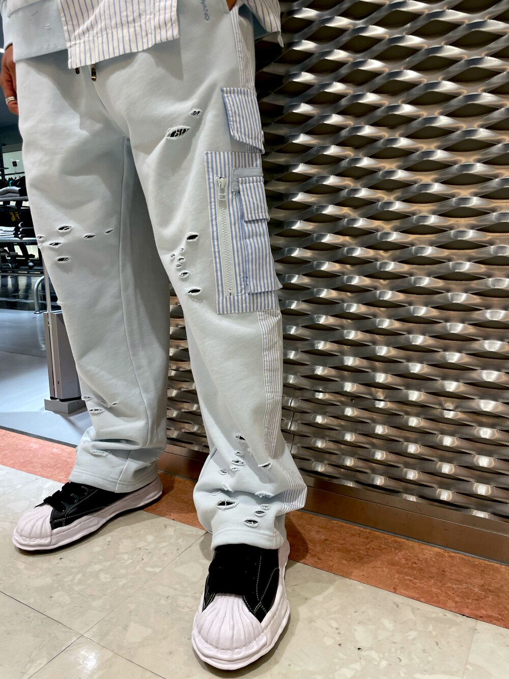 ブルー系のパーカー、ブルー系のスウェットパンツ、ブラック系のスニーカーを着用したメンズの冬コーディネートの5枚目の写真