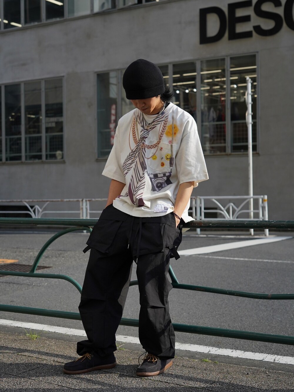ホワイト系のTシャツ/カットソー、ブラック系のカーゴパンツを着用したメンズの春コーディネートの2枚目の写真