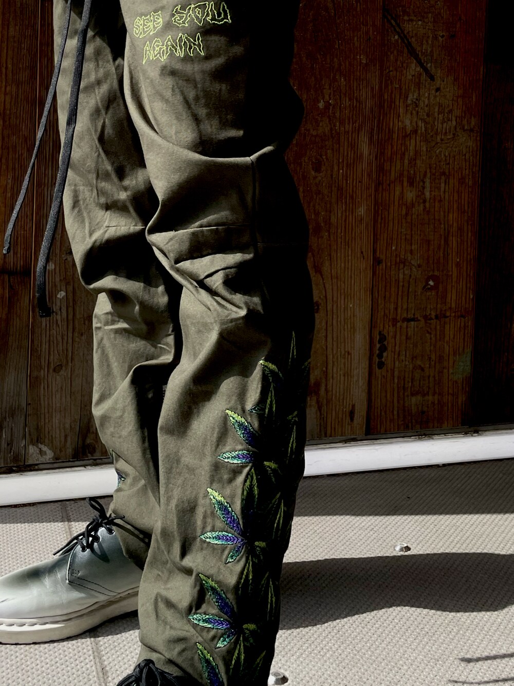 ブラック系のシャツ/ブラウス、ブラック系のTシャツ/カットソー、グリーン系のその他パンツを着用したメンズの春コーディネートの2枚目の写真