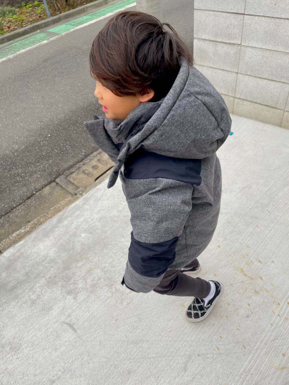 ブラック系のスニーカー、グレー系のダウンジャケット/コート、ホワイト系のTシャツ/カットソーを着用したキッズの冬コーディネートの2枚目の写真
