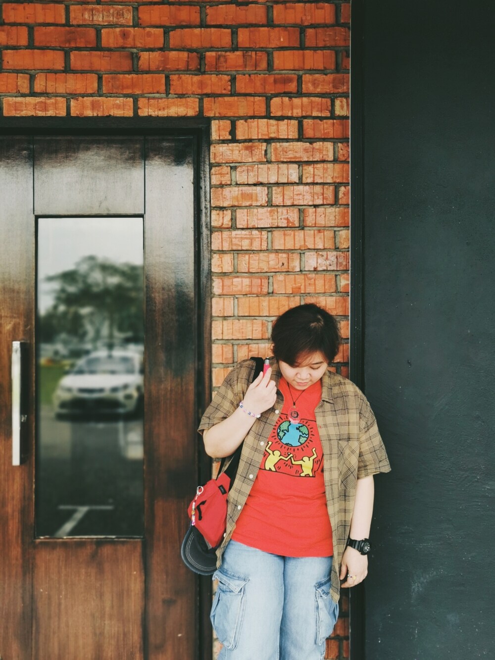 ブルー系のデニムパンツ、オレンジ系のTシャツ/カットソー、ベージュ系のシャツ/ブラウスを着用したレディースの冬コーディネートの2枚目の写真