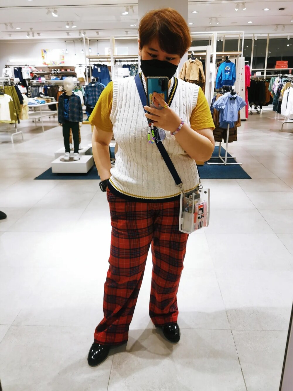 レッド系のスラックス、ホワイト系のカーディガン/ボレロ、レッド系のテーラードジャケットを着用したレディースの冬コーディネートの2枚目の写真