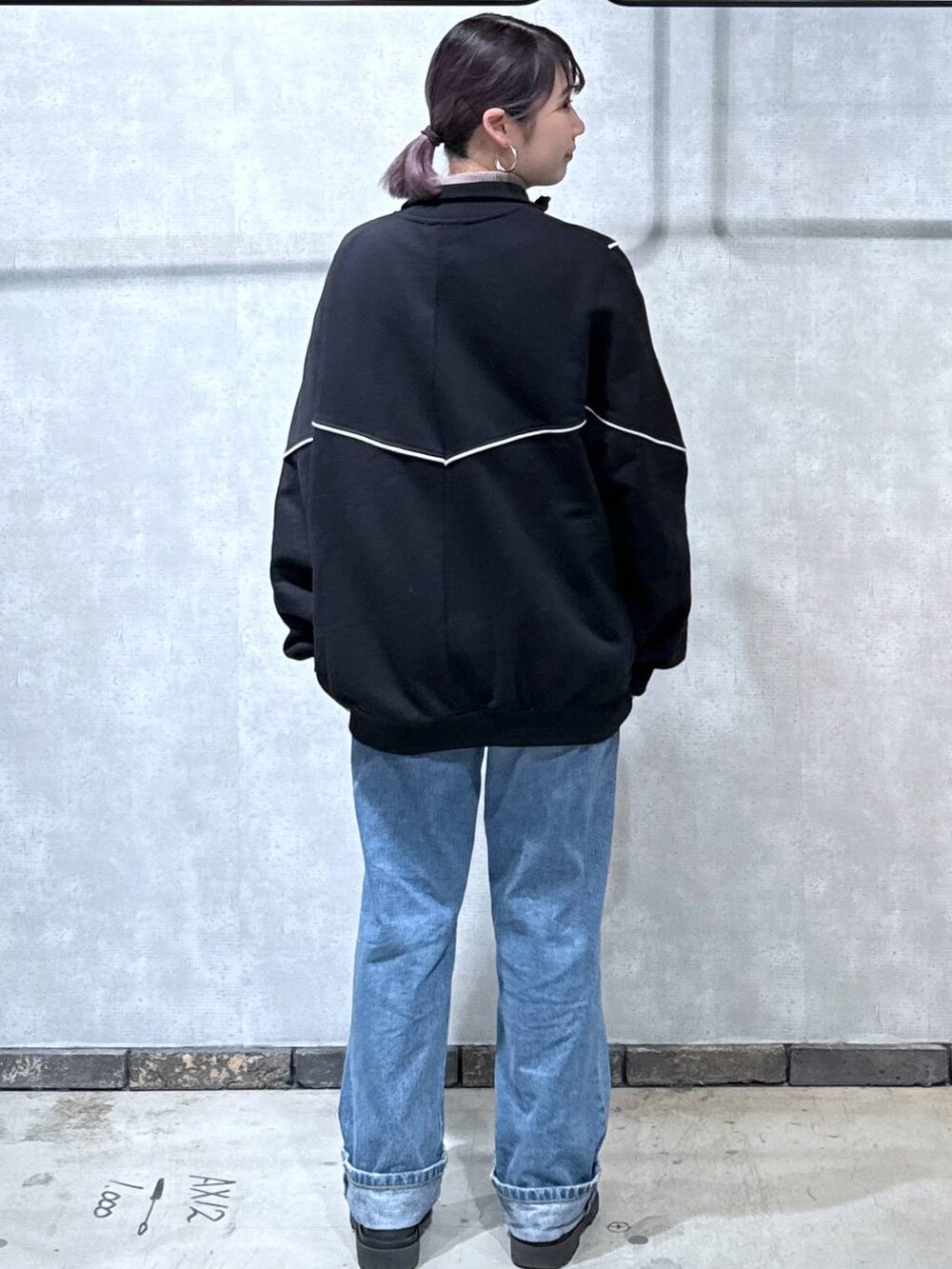 ブルー系のデニムパンツ、ブラウン系のニット/セーター、ブラック系のスウェットを着用したレディースの冬コーディネートの3枚目の写真