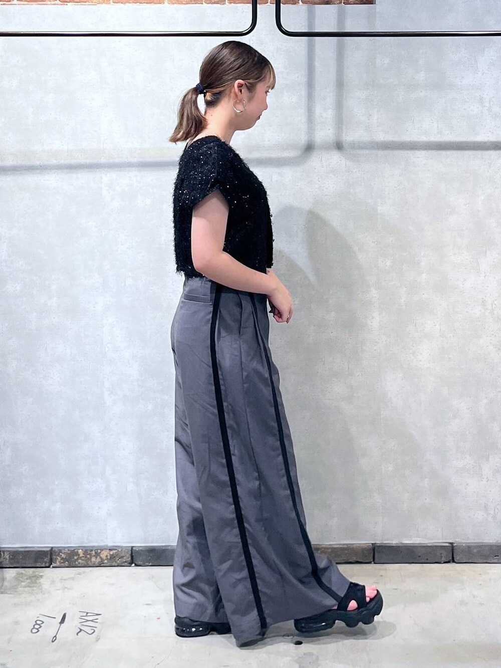 ブラック系のTシャツ/カットソー、グレー系のスラックスを着用したレディースの夏コーディネートの4枚目の写真