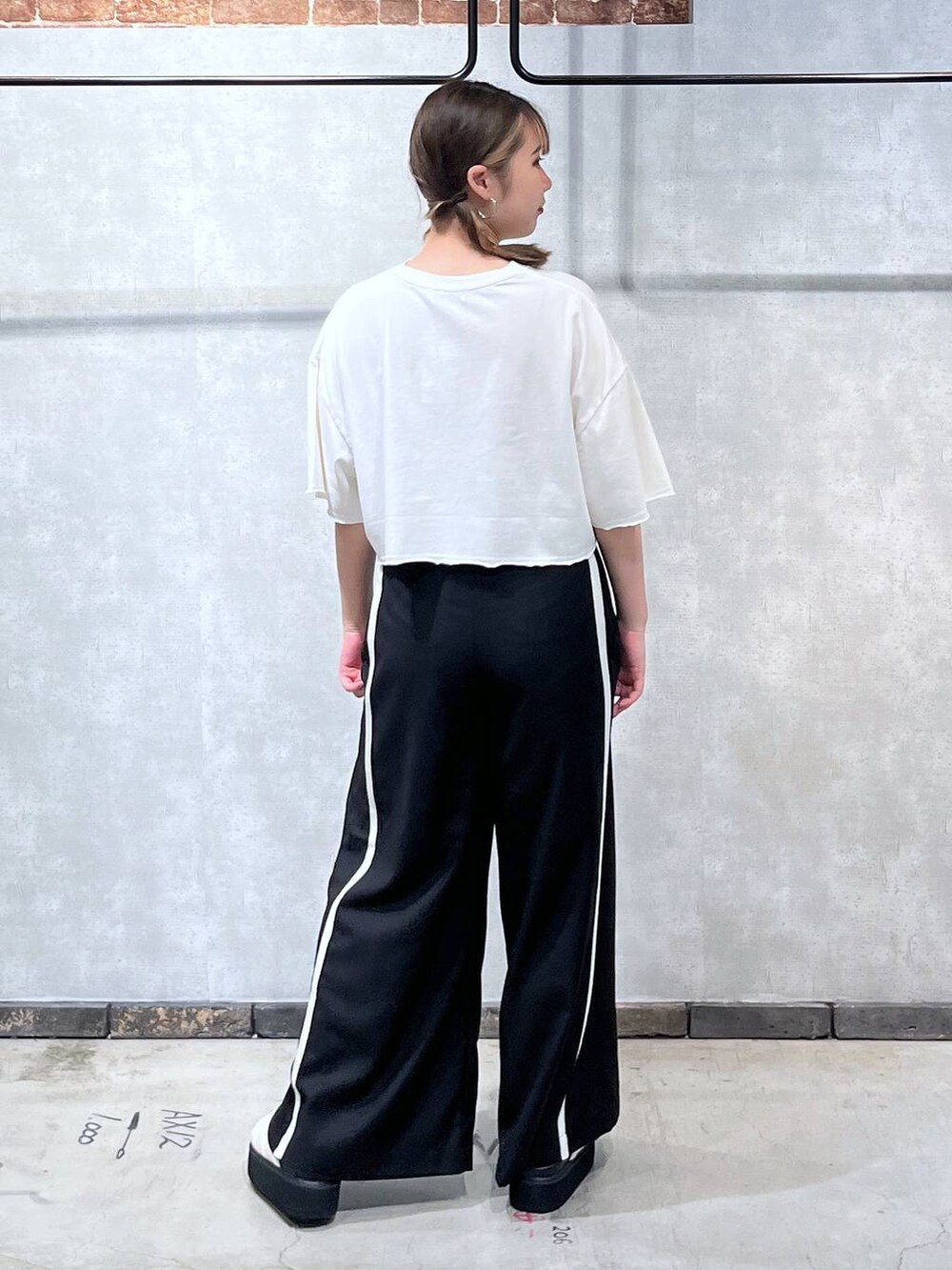 ホワイト系のサンダル、ホワイト系のTシャツ/カットソー、ブラック系のスラックスを着用したレディースの夏コーディネートの4枚目の写真