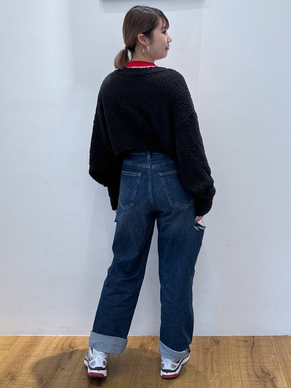 ブラック系のニット/セーター、ブルー系のデニムパンツ、レッド系のニット/セーターを着用したレディースの春コーディネートの3枚目の写真