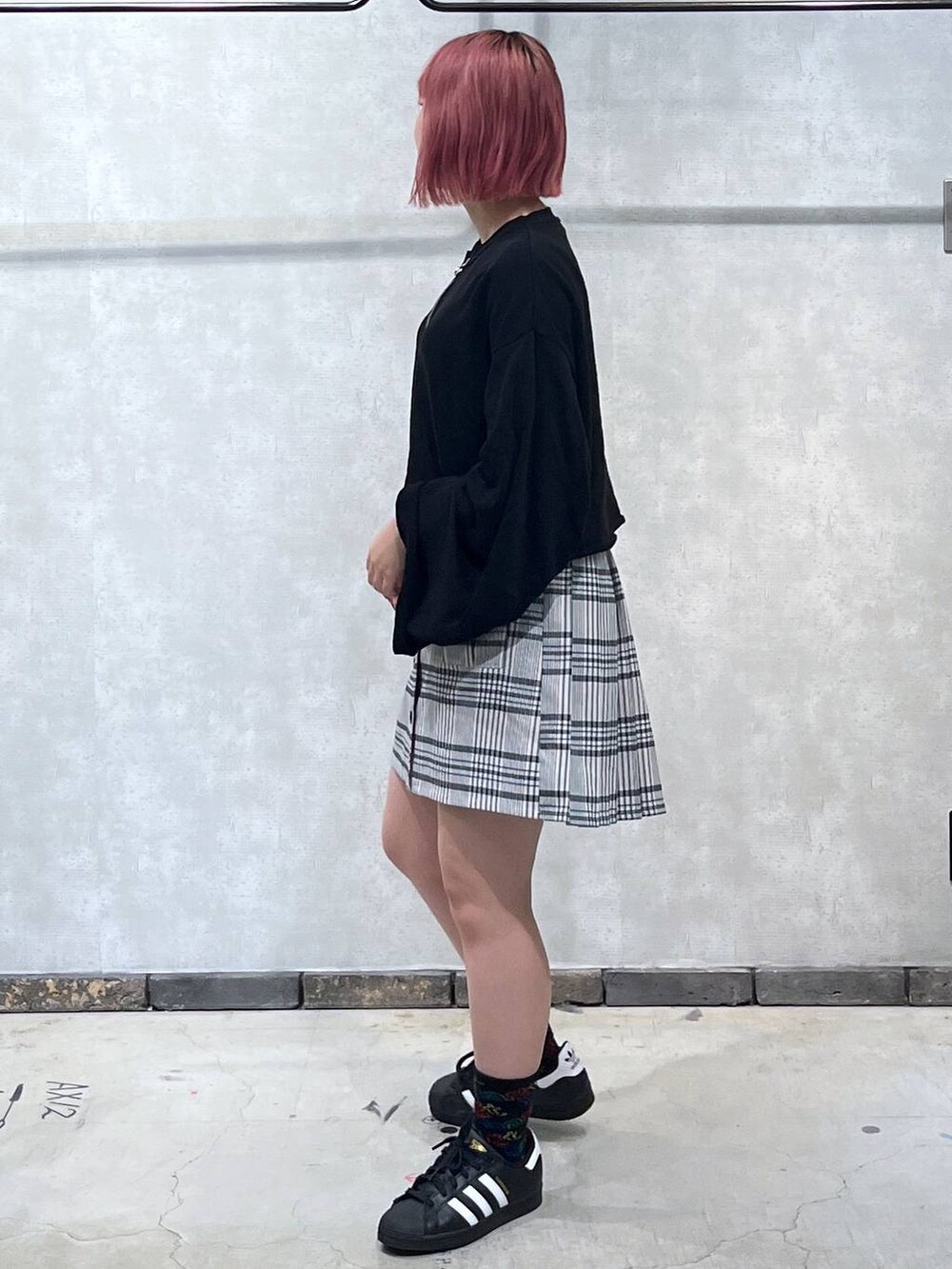 ブラック系のTシャツ/カットソー、ホワイト系のスカートを着用したレディースの秋コーディネートの2枚目の写真