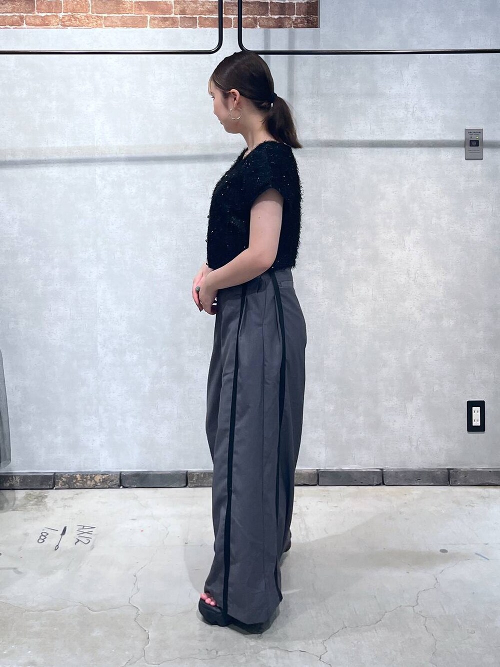 ブラック系のTシャツ/カットソー、グレー系のスラックスを着用したレディースの夏コーディネートの2枚目の写真