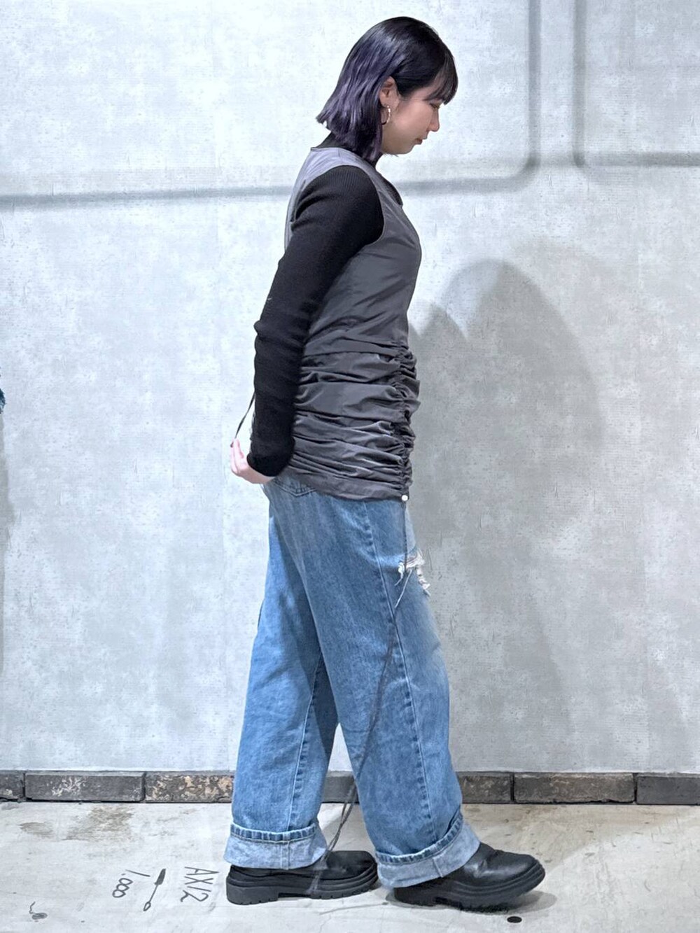 グレー系のワンピース、ブラック系のニット/セーター、ブルー系のデニムパンツを着用したレディースの冬コーディネートの4枚目の写真