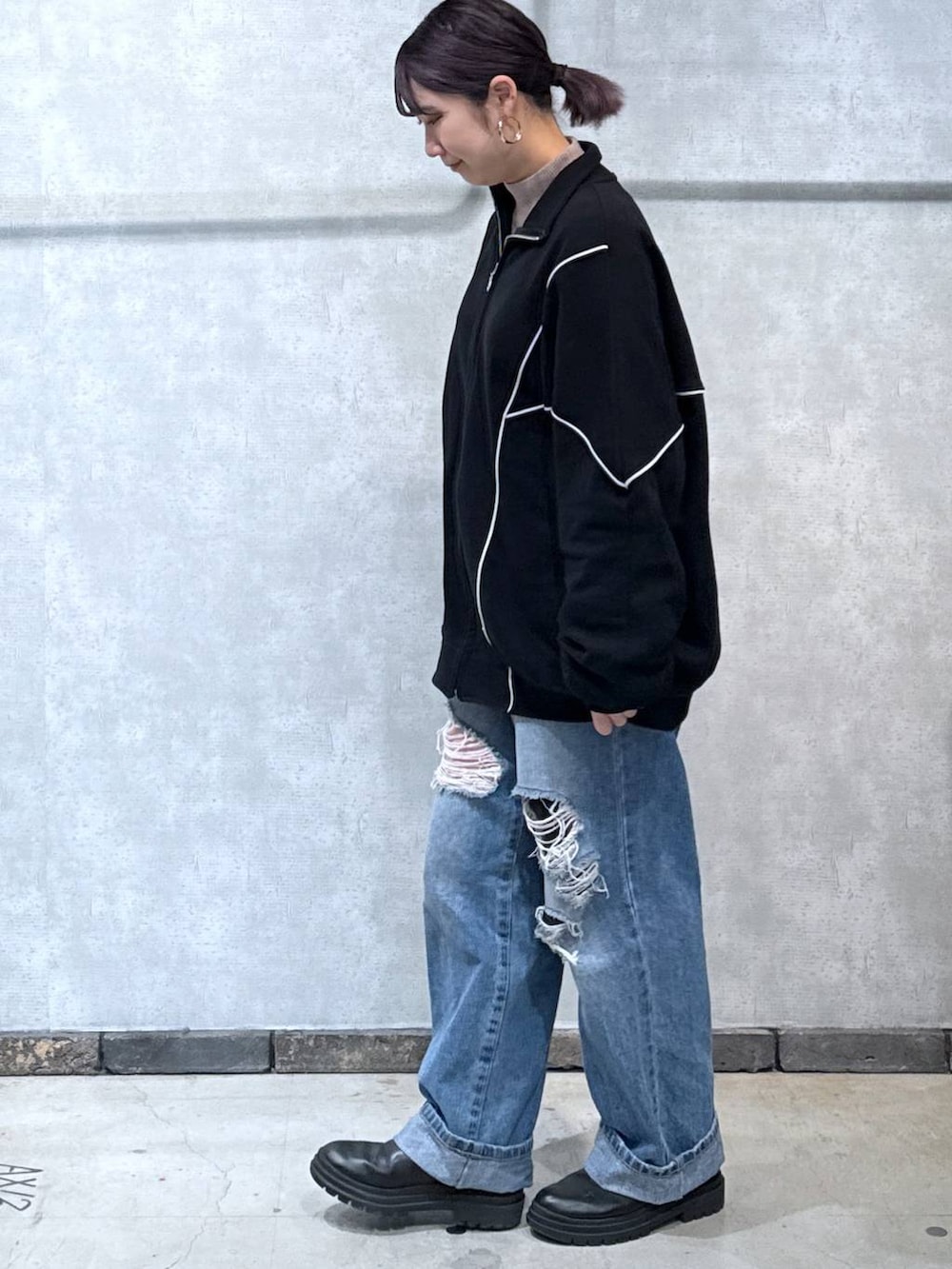 ブルー系のデニムパンツ、ブラウン系のニット/セーター、ブラック系のスウェットを着用したレディースの冬コーディネートの2枚目の写真