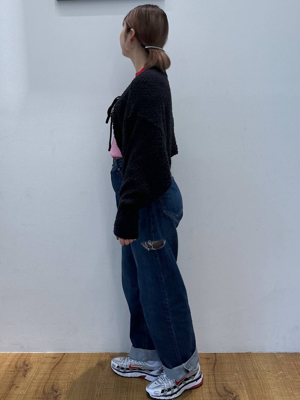 ブラック系のニット/セーター、ブルー系のデニムパンツ、レッド系のニット/セーターを着用したレディースの春コーディネートの2枚目の写真