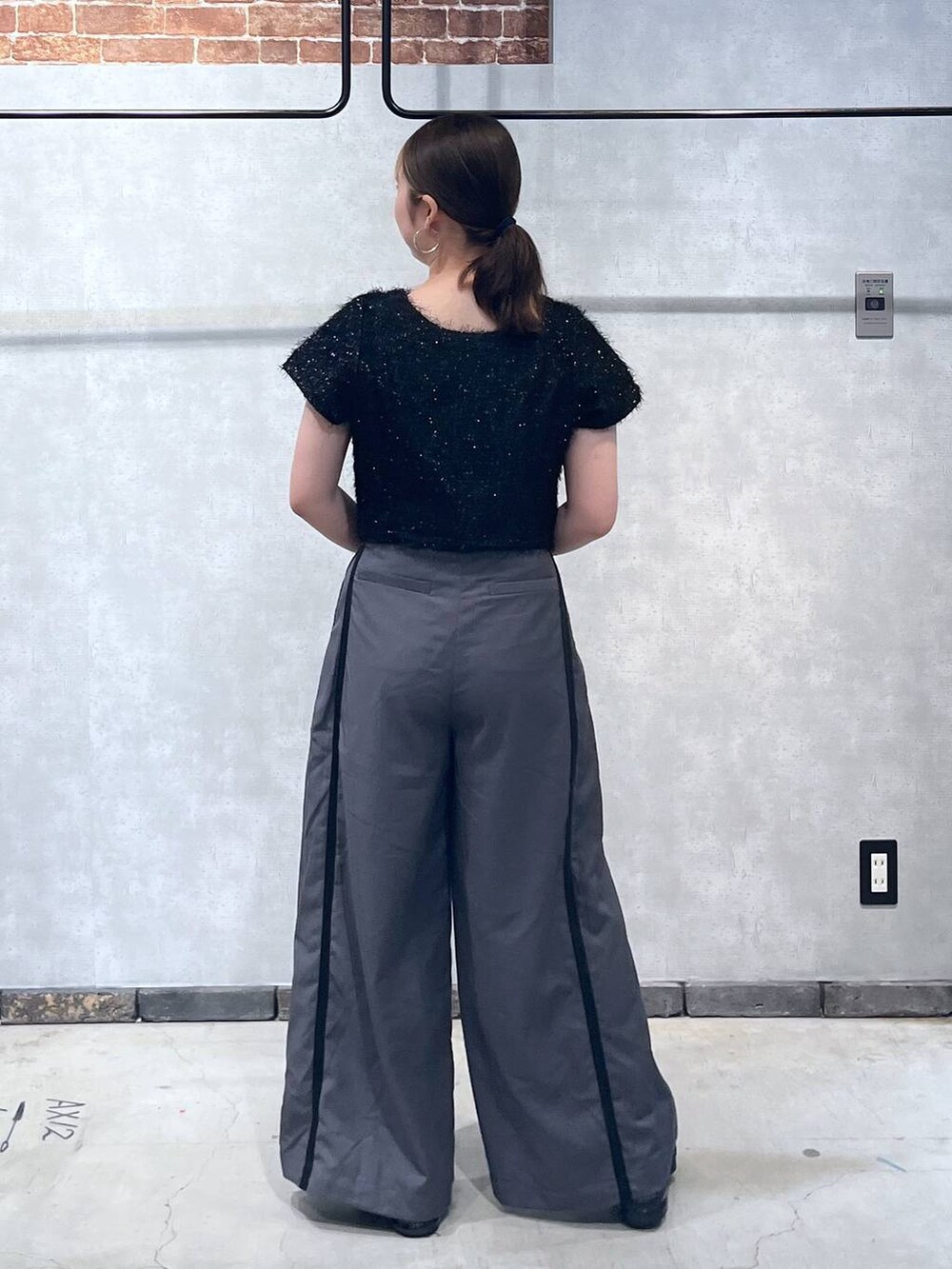 ブラック系のTシャツ/カットソー、グレー系のスラックスを着用したレディースの夏コーディネートの3枚目の写真