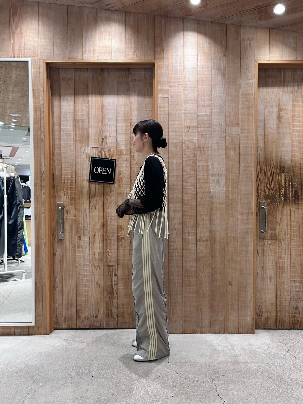 ホワイト系のベスト、ブラック系のTシャツ/カットソー、グレー系のスウェットパンツを着用したレディースの春コーディネートの2枚目の写真