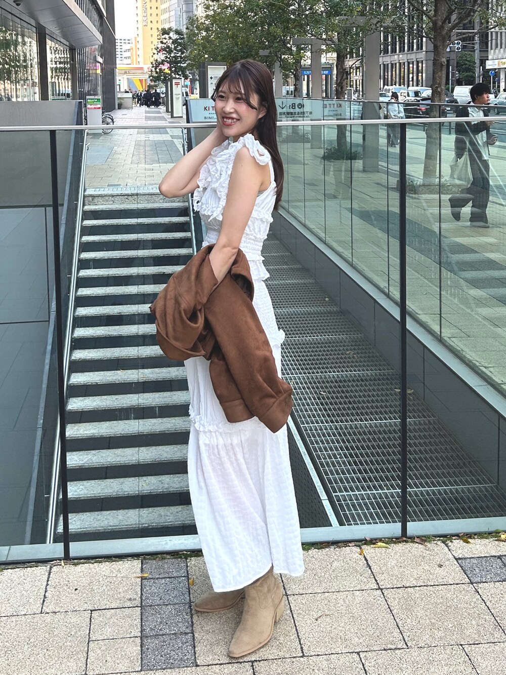 イエロー系のシャツ/ブラウス、ホワイト系のワンピース、ベージュ系のブーツを着用したレディースの春コーディネートの2枚目の写真