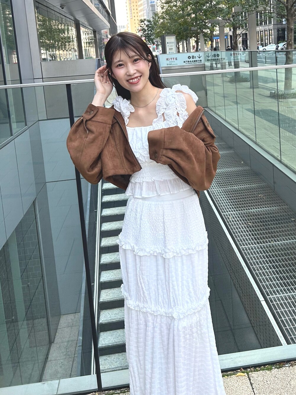 イエロー系のシャツ/ブラウス、ホワイト系のワンピース、ベージュ系のブーツを着用したレディースの春コーディネートの4枚目の写真
