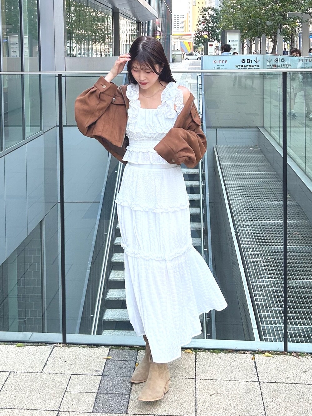 イエロー系のシャツ/ブラウス、ホワイト系のワンピース、ベージュ系のブーツを着用したレディースの春コーディネートの3枚目の写真
