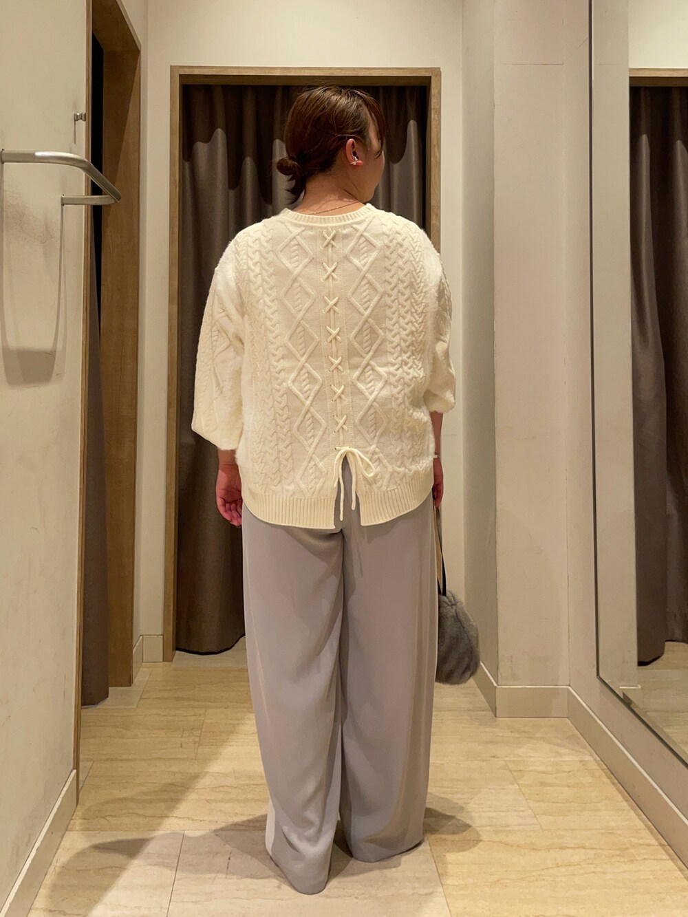 ホワイト系のニット/セーター、ホワイト系のその他パンツ、ブラック系のトートバッグを着用したレディースの秋コーディネートの2枚目の写真