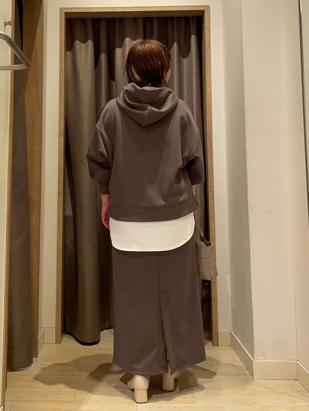 グレー系のワンピース、ブラウン系のトートバッグを着用したレディースの秋コーディネートの2枚目の写真